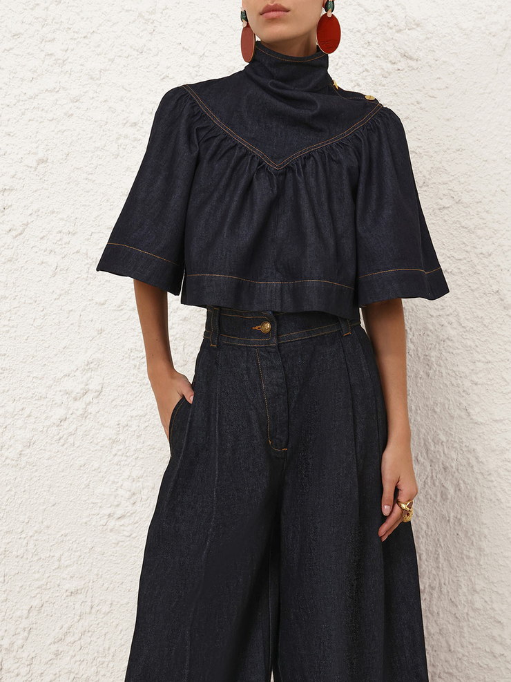 Input: a denim cape top photographed close, cropped above the head and below the thigh