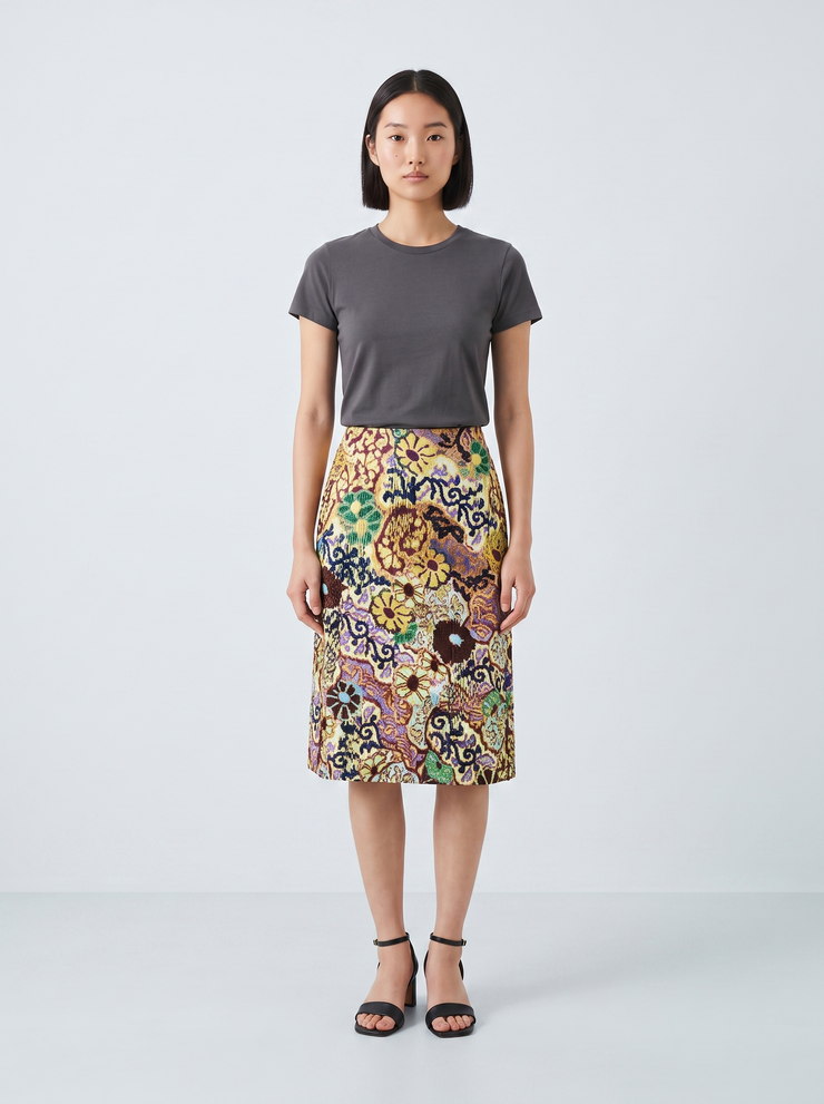 Output: the same embellished skirt with a plain gray tee on a studio sweep