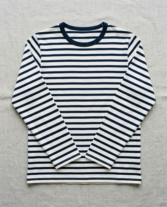 Flat lay of a navy and white striped long-sleeve top on linen