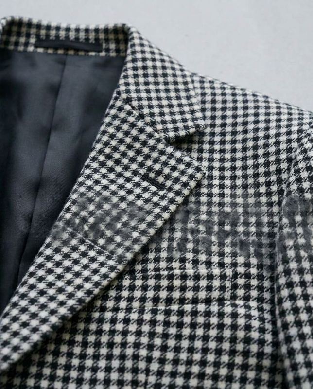 Reconstruction of a rejected frame: Mid-fabric the houndstooth forgets its own pattern and dissolves into smudge.