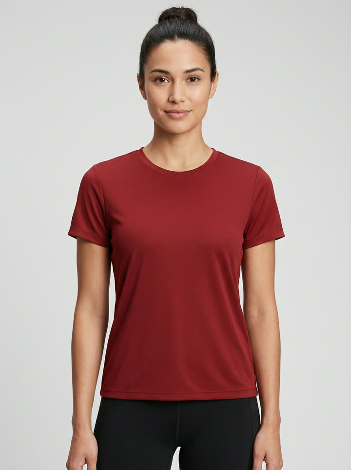 A woman in a deep red performance tee on a gray sweep, the reference image
