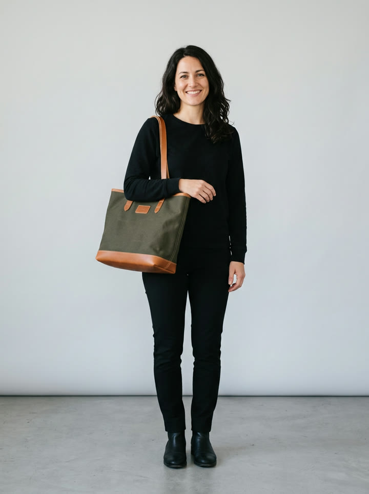 A woman carrying a medium olive canvas tote on her shoulder at hip height, the reference image